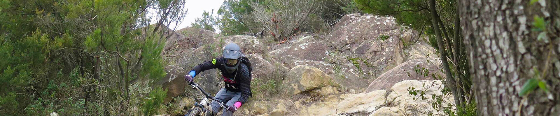 Biker downhill between rocks and slopes